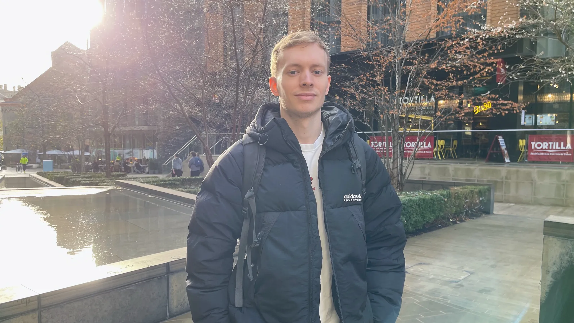 Matt Holman standing in a London square in low winter sunlight.